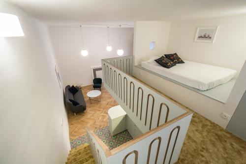 a small room with a bed and a staircase at Downtown Designer apartment Karlin in Prague
