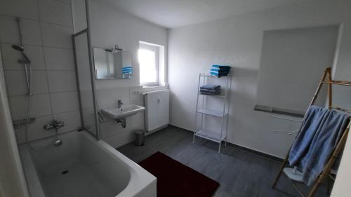a bathroom with a bath tub and a sink at Ferienwohnung Rolf in Crottendorf