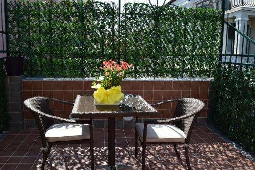 a table and chairs with a vase of flowers on it at Hotel Lido in Varazze
