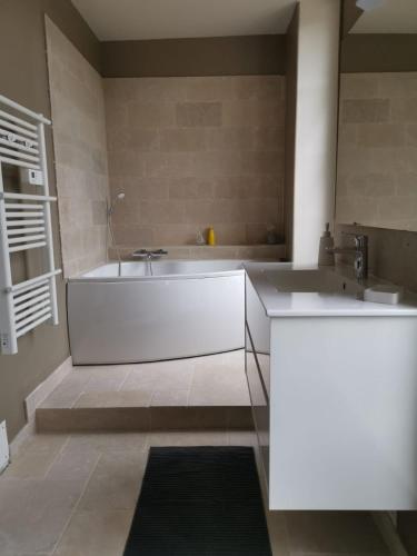 une salle de bain avec une baignoire et un lavabo dans l'établissement Villa Sainte-Marie - Les Bastides d'Edouard - Chablis, à Maligny