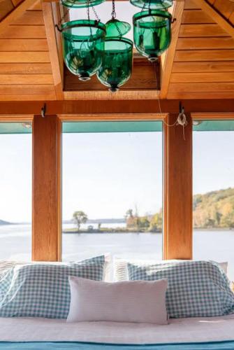a bedroom with a view of the water in a house at Hudson Riverfront Home in Catskill