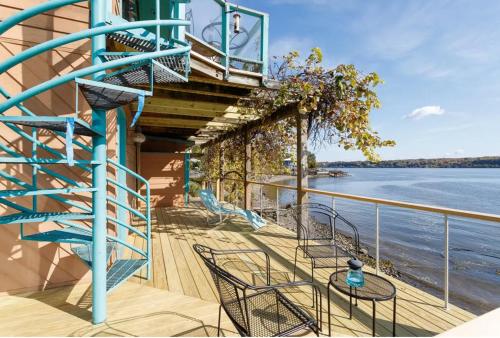 a balcony with a blue spiral staircase next to the water at Hudson Riverfront Home in Catskill