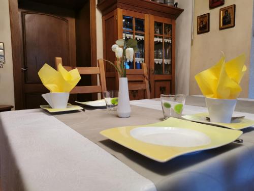马尔平根Gästehaus Schu的一张桌子上铺着黄色餐巾，上面放着一个黄色盘子。