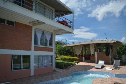 une maison avec une piscine à côté d'un bâtiment dans l'établissement Hotel Campestre Sueño del Abuelo, à Pereira