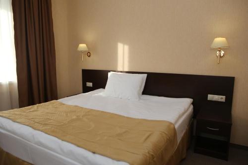 a bed in a hotel room with a pillow on it at Hotel Aner in Astana