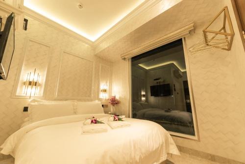 a bedroom with a large white bed with a mirror at AJ Residence - Above Peppermint Asia City in Kota Kinabalu