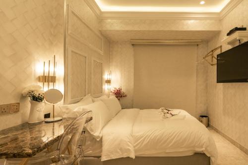 a white room with two beds and a table at AJ Residence - Above Peppermint Asia City in Kota Kinabalu