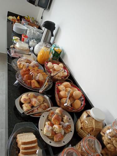 einen Tisch mit verschiedenen Frühstückslebensmitteln in der Unterkunft Pousada Bella Capitólio in Capitólio