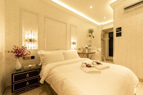 una camera da letto con un grande letto bianco con fiori di AJ Residence - Above Peppermint Asia City a Kota Kinabalu