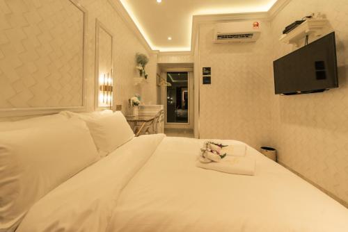 a hotel room with a white bed with a towel on it at AJ Residence - Above Peppermint Asia City in Kota Kinabalu