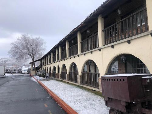 a building with snow on the ground next to a street at Eldorado Inn in Baker City