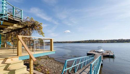 a house on the water with a dock and a boat at Hudson Riverfront Home in Catskill