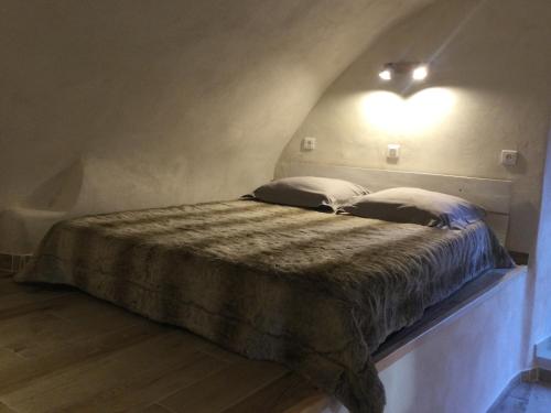 - un lit avec deux oreillers et une lumière sur le mur dans l'établissement Casa LiLi, à Castello-di-Rostino