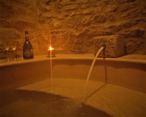 a candle in a bathroom with a bath tub with a lit candle at La Scalinata Apartment in Perugia