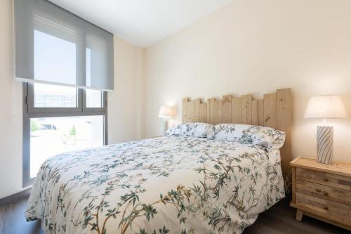 a bedroom with a bed and a window at Apartamento Las Margas Golf Pirineo Aragones in Sabiñánigo