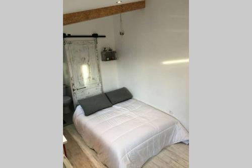 a small white bed in a white room at Studio chocolat in Marquise