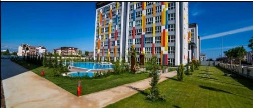 a large apartment building with a swimming pool in a park at PLT Lego Holiday Village Antalya in Antalya