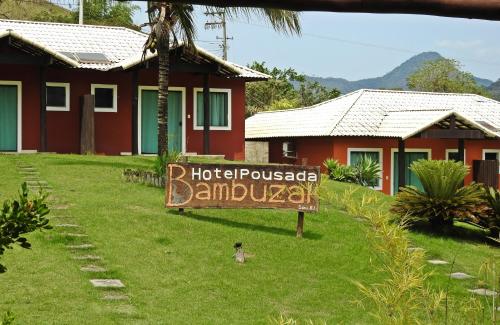 a sign in the grass in front of a house at Hotel Pousada Bambuzal in Sana