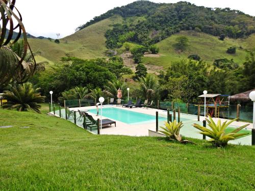 uma piscina com uma montanha ao fundo em Hotel Pousada Bambuzal em Sana