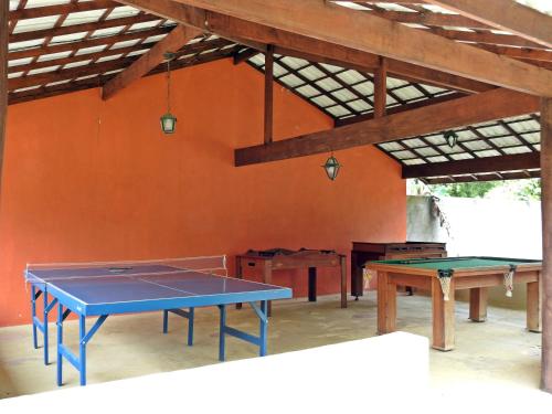 a ping pong table in a room with an orange wall at Hotel Pousada Bambuzal in Sana