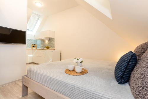 a bedroom with a bed with two mugs on it at Apartmány Jedovary in Trhové Sviny