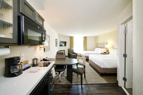 Habitación de hotel con cocina y dormitorio en Candlewood Suites Columbus-Northeast, an IHG Hotel, en Columbus