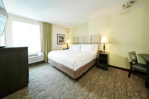 una camera d'albergo con un letto, una scrivania e una finestra di Candlewood Suites Columbus-Northeast by IHG a Columbus