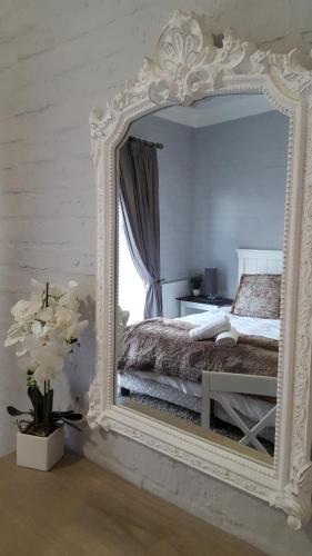 Un espejo grande en un dormitorio con cama. en 128 Clarens Golf Villa, en Clarens