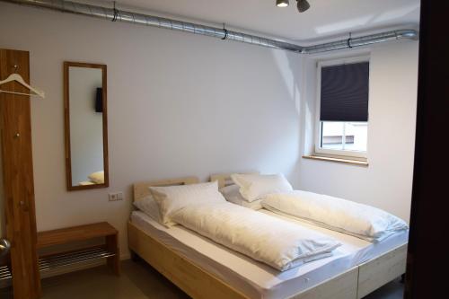 een bed in een kamer met een spiegel en een raam bij Herberge Bärenschenke in Meßkirch