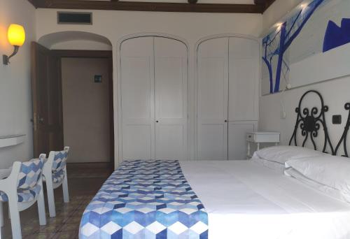 a bedroom with a large bed with a blue and white blanket at Taverna Del Capitano in Massa Lubrense