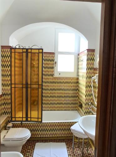 a bathroom with a tub and a toilet and a sink at Taverna Del Capitano in Massa Lubrense
