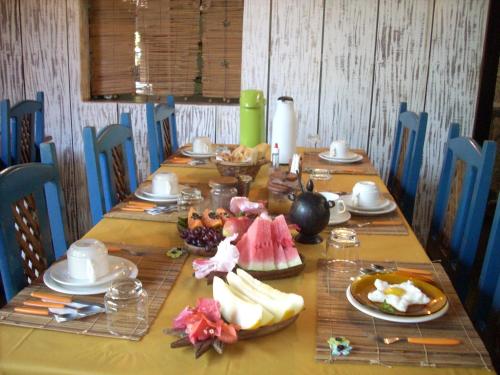 a long table with plates of food on it at Pousada Bucaneiros in Arraial d'Ajuda