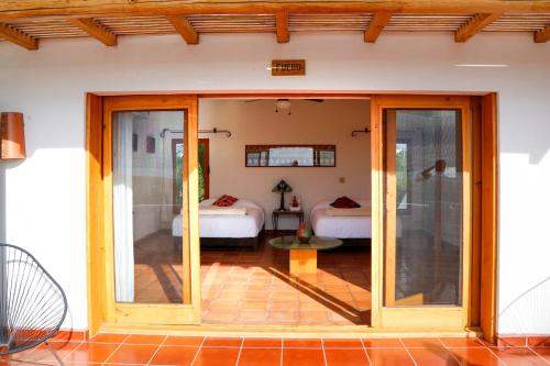a room with sliding glass doors with two beds at Tribu Todos Santos in Todos Santos