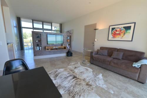 a living room with a couch and a tv at The Waters in Motueka