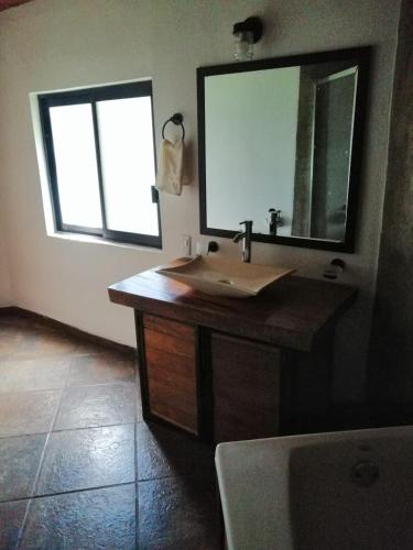 a bathroom with a sink and a mirror and a tub at Mazamitla Pinos del Rio in Mazamitla