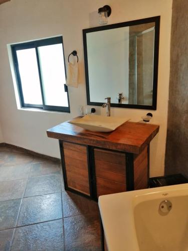 a bathroom with a sink and a mirror and a toilet at Mazamitla Pinos del Rio in Mazamitla