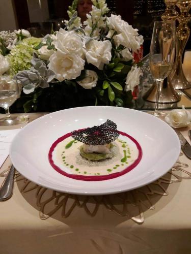 a plate with a dessert on a table with flowers at Keliki Luxury Lodge in Ubud