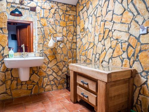 a bathroom with a sink and a stone wall at Siedlisko Poleski Zakątek in Lejno
