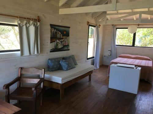 Habitación con cama, mesa y silla en Cabañas Utopía en Punta del Diablo