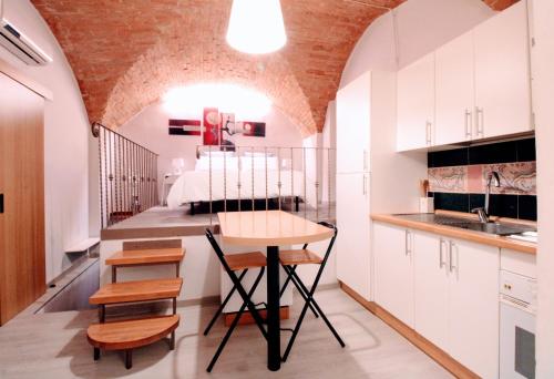a small kitchen with a table and a bed at Suite al Duomo in Siena