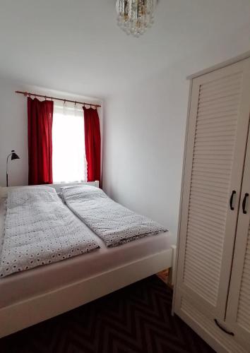 łóżko w pokoju z czerwonym oknem w obiekcie Rubin Apartment w Kielcach