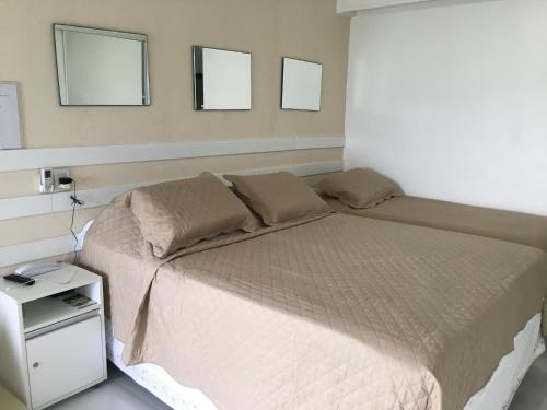 a bedroom with a bed with two mirrors on the wall at Ap 210 Bahia Flat, Barra in Salvador