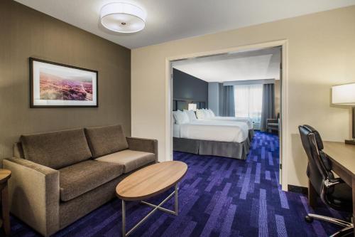 Habitación de hotel con sofá y cama en Holiday Inn & Suites Grande Prairie, an IHG Hotel, en Grande Prairie