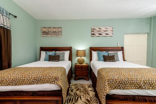 dos camas sentadas una al lado de la otra en una habitación en Hotel Tim Bamboo, en Port Antonio