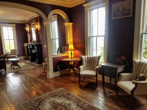 a living room with chairs and a table and windows at Iron Horse Hotel in Blackwater