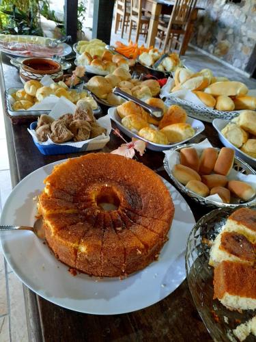a table full of different types of food on plates at Pousada Icthus in Cabo Frio