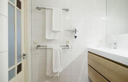 een badkamer met witte handdoeken en een wastafel bij Ground floor Jordaan Apartment in Amsterdam