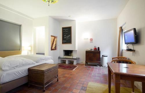 a bedroom with a bed and a desk and a tv at Ground floor Jordaan Apartment in Amsterdam