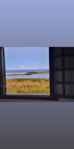 an open window with a view of a field at Pousada Icthus in Cabo Frio