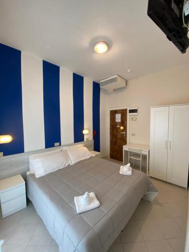a bedroom with a large bed with blue and white stripes at Family Hotel Las Vegas in Riccione